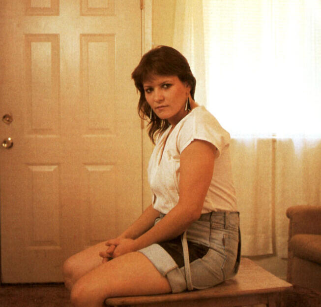 wendy mckee sits on a coffee table facing a television set this young woman was the victim of Bill Robert Cathey a professor who kidnapped her and tried to brainwash her into being the perfect woman