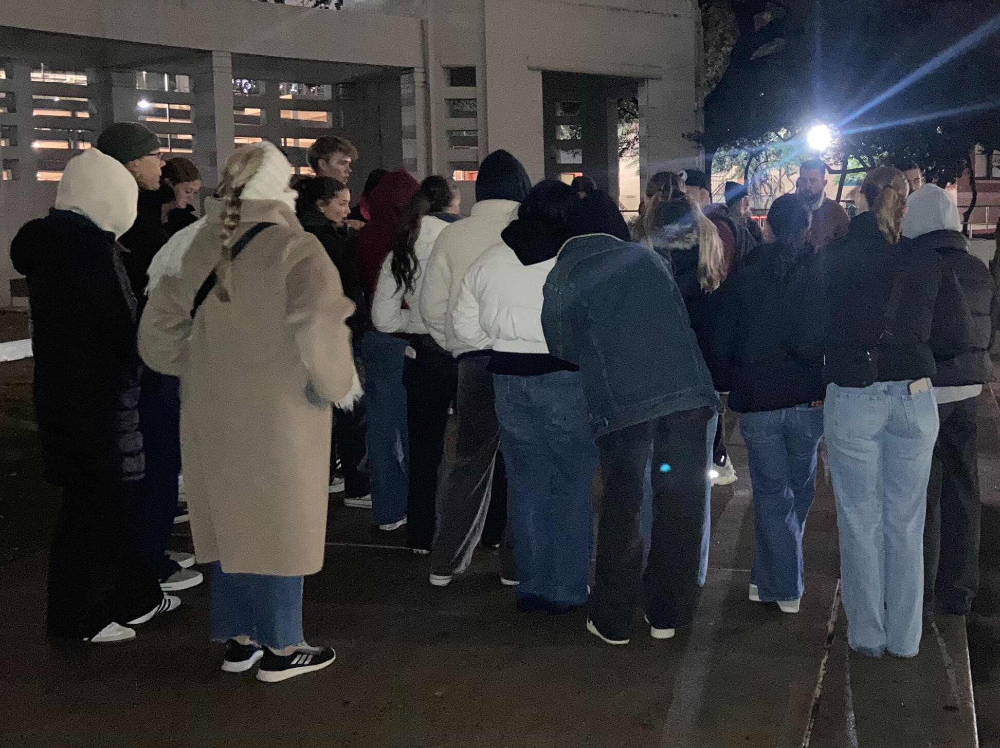 A photo from one of our true crime walking tours showing a crowd of people gather on the grassy knoll listening to our tour guide tell his story
